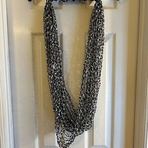 Women’s black & silver scarf. This scarf is pre-owned and in good condition.